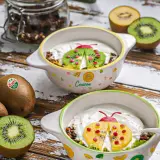 Recette kiwi trop mûr : yaourt et granola décorés d'une coccinelle en kiwi et fruits rouges. Parfait pour un petit-déjeuner ludique.
