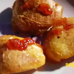 Trois morceaux de coing au four, nappés de miel et d'une touche de confiture rouge. Un délice sucré et parfumé.