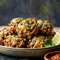 Beignets croustillants d'aubergine, parsemés d'herbes et servis avec des quartiers de citron. Un délice à savourer !