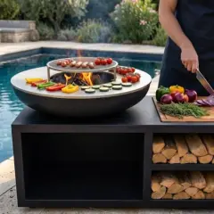 Un brasero plancha DIY prêt pour un festin au bord de la piscine. Saucisses grillées, légumes colorés et feu de bois crépitant.
