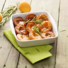 Abricots rôtis au four, tendres et caramélisés, garnis de romarin frais. Un délice simple et parfumé.