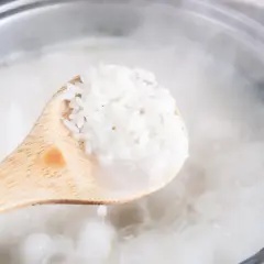 Une cuillère en bois sort du riz trop cuit bouillant dans une casserole. Que faire ?