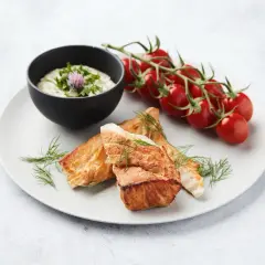 Délicieux cabillaud au barbecue, servi avec une sauce crémeuse, des tomates cerises et de l'aneth frais.