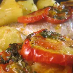 Dorade au four portugaise avec pommes de terre et tomates rôties, un plat savoureux et coloré.