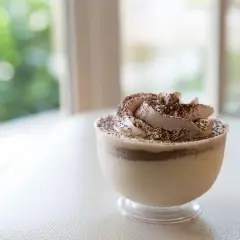 Délicieuse mousse au café sans cuisson, garnie de cacao, dans un verre transparent. Parfait pour une pause gourmande.