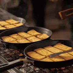 Poêles remplies de tofu doré sur un gril, prêtes pour une délicieuse barbeclette recette.