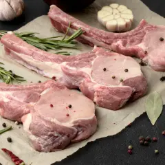 Belle découpe de cochon crue, assaisonnée de poivre et d'herbes, prête pour un festin.