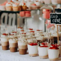 Un buffet de desserts festif, parfait pour une idée repas mariage été, avec des cupcakes, verrines et macarons.