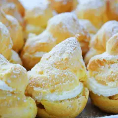 Choux garnis de crème, saupoudrés de sucre glace. Pour qu'ils restent gonflés, il faut bien cuire la pâte à choux et ne pas ouvrir le four trop tôt.