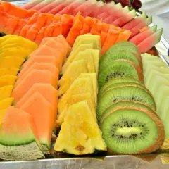 Présentation de fruits pour mariage : plateau coloré de pastèque, melon, papaye, ananas et kiwi coupés en éventail.