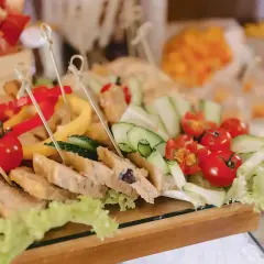 Un buffet froid festif pour un buffet départ retraite : brochettes de tomates cerises, concombres, poivrons et tranches de pain garnies.