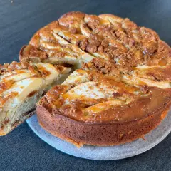 Gâteau pomme spéculoos, une part coupée révèle la texture moelleuse et les morceaux de spéculoos. Un délice gourmand.