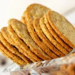 Une pile de crackers croustillants, parfaits pour une recette de crackers fromage. Ils sont dorés et parsemés de sel.