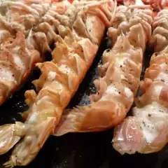 Langoustines grillées, assaisonnées de poivre, prêtes pour un barbecue savoureux.