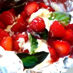 Fraises et crème dans du papier d'aluminium, un délicieux dessert pour barbecue.