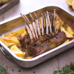 Un délicieux côte d'agneau rôti au four, accompagné de pommes de terre dorées et de romarin frais. Un plat savoureux prêt à être dégusté.