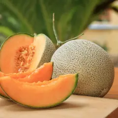 Un melon coupé en quartiers et un entier sur une planche à découper. Idéal pour savoir que faire avec un melon pas bon : le transformer en sorbet !