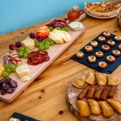 Un buffet champêtre gourmand : planches de charcuterie, fromages, raisins, mini-quiches et toasts saumon.