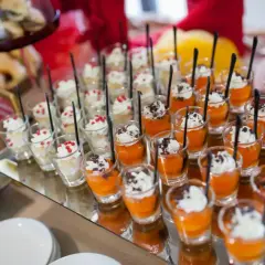 Petits desserts individuels en verrines, certains à la crème et fruits rouges, d'autres à la mousse orange et copeaux de chocolat. Un nom de menu original serait parfait pour ces délices.