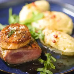 Tournedos de canard cuisson parfaite, garni de foie gras poêlé, servi avec une purée de pommes de terre et des roquettes.