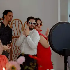 Des invités s'amusent avec des lunettes en forme de cœur lors d'un repas enfant mariage.