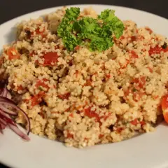 Taboulé traiteur frais, garni de persil et tomates. Le prix est très attractif pour cette spécialité méditerranéenne.