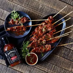 Brochettes de bœuf glacées à la marinade Jack Daniel's, servies avec une sauce barbecue.