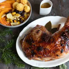 Une cuisse de dinde rôtie, brillante et savoureuse, parfaite pour une recette cuisse de dinde originale. Accompagnée de légumes et de petites bouchées.