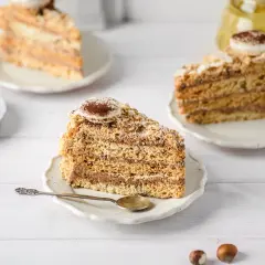 Tranches de gâteau moelleux aux noisettes de ma mamie, garnies de crème au chocolat et saupoudrées de cacao. Un délice !