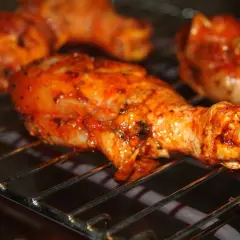 Cuisses de poulet marinées, grillées au barbecue charbon, dégoulinant de sauce savoureuse.