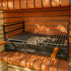 Barbecue en briques avec grille prête pour le temps de cuisson barbecue charbon. Les braises attendent d'être allumées pour un festin en plein air.