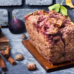 Gâteau rustique aux figues et noix, garni de fruits frais, de cannelle et de noisettes.