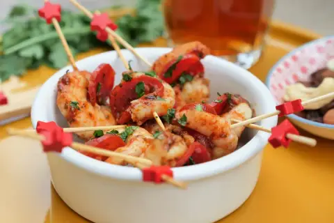 Brochettes crevette chorizo, garniture de persil frais, sur des bâtonnets décorés d'étoiles rouges. Un délice pour l'apéritif !