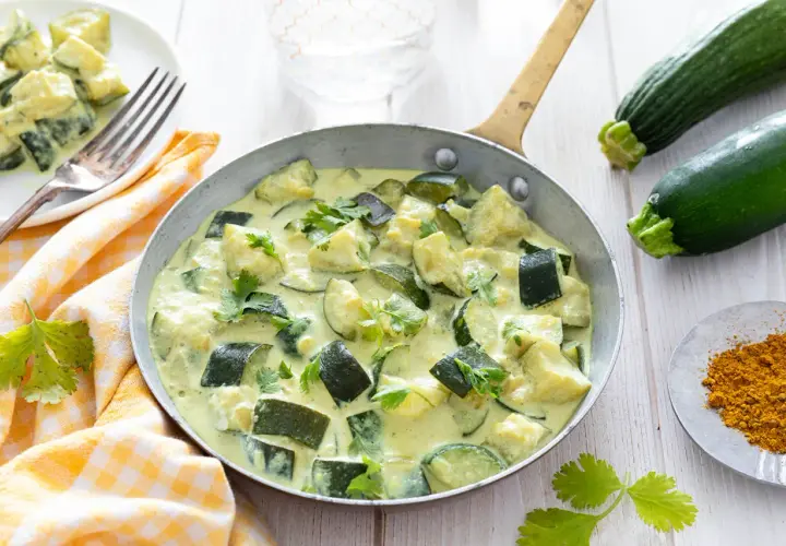 Délicieux curry de courgettes crémeux, une des 10 recettes courgettes à essayer. Garniture de coriandre fraîche.