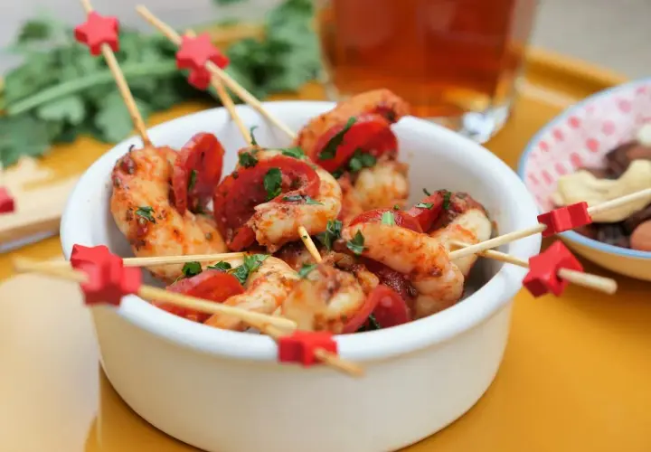 Brochettes crevette chorizo, garniture de persil frais, sur des bâtonnets décorés d'étoiles rouges. Un délice pour l'apéritif !