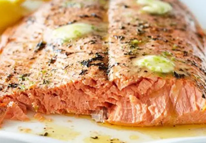 Un pavé de saumon barbecue, cuit à la perfection, avec des éclats de beurre fondant et des herbes.