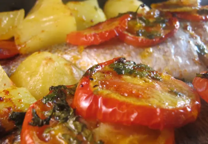 Dorade au four portugaise avec pommes de terre et tomates rôties, un plat savoureux et coloré.