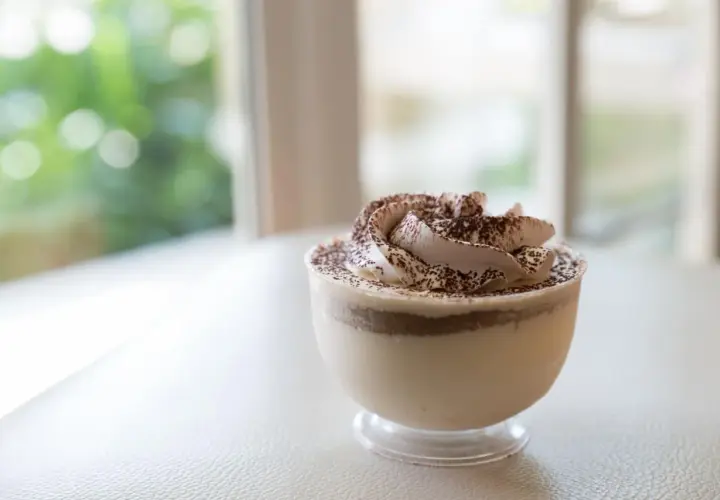Délicieuse mousse au café sans cuisson, garnie de cacao, dans un verre transparent. Parfait pour une pause gourmande.