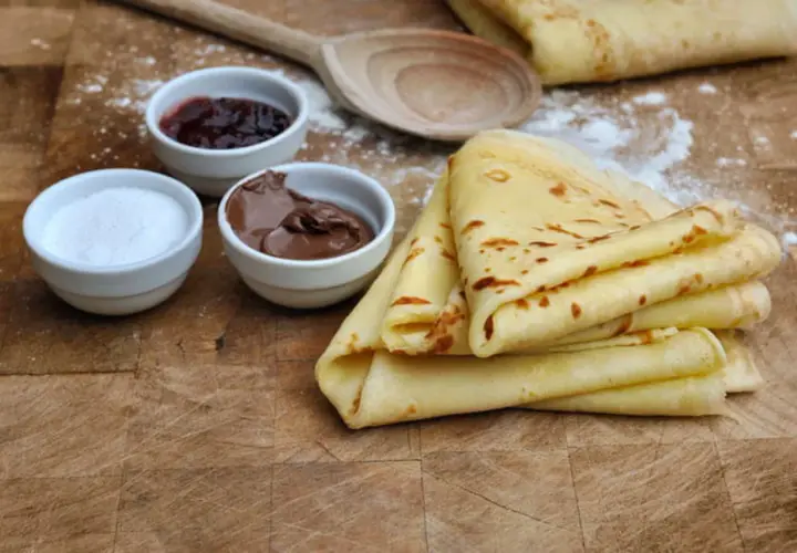 Crêpes sans lactose dorées, accompagnées de confiture, pâte à tartiner et sucre. Un délice pour tous !