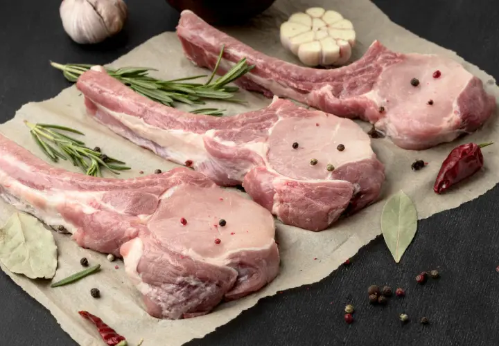 Belle découpe de cochon crue, assaisonnée de poivre et d'herbes, prête pour un festin.