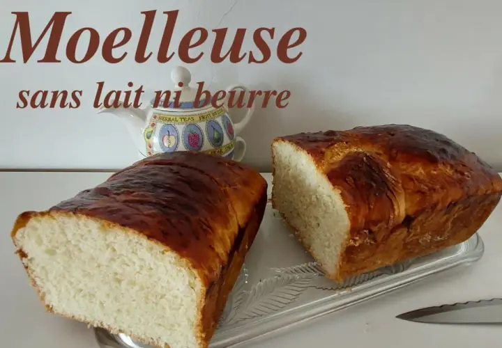 Deux belles brioches moelleuses sans lait ni beurre, dorées et appétissantes, prêtes à être dégustées.