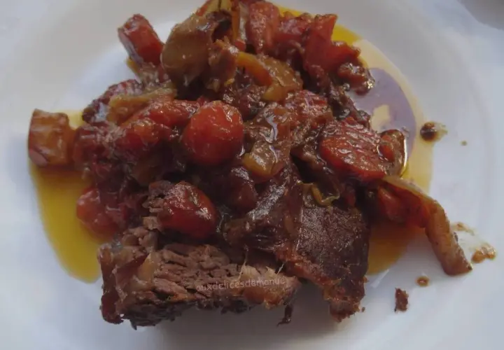 Un morceau de côte de bœuf mijoté, nappé d'une sauce aux tomates et oignons caramélisés. Parfait pour une marinade pour côte de bœuf maison.