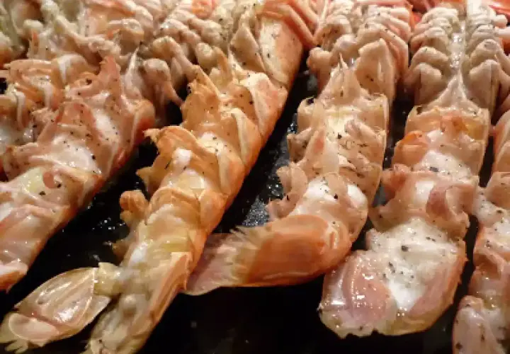 Langoustines grillées, assaisonnées de poivre, prêtes pour un barbecue savoureux.