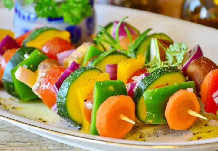 Brochettes de légumes colorées, une excellente idée accompagnement barbecue. Courgettes, poivrons, carottes, tomates et oignons rouges assaisonnés.