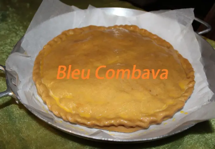 Une empanada gallega dorée, prête à être dégustée. Le texte "Bleu Combava" est superposé.