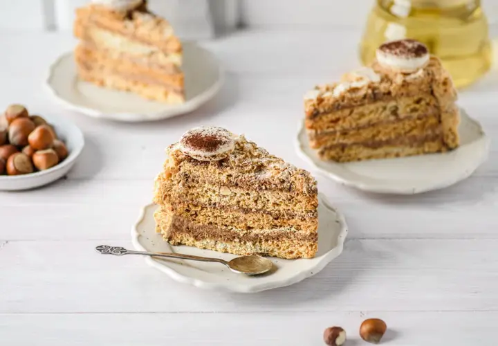Tranches de gâteau moelleux aux noisettes de ma mamie, garnies de crème au chocolat et saupoudrées de cacao. Un délice !