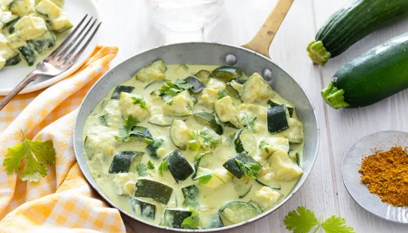 Délicieux curry de courgettes crémeux, une des 10 recettes courgettes à essayer. Garniture de coriandre fraîche.