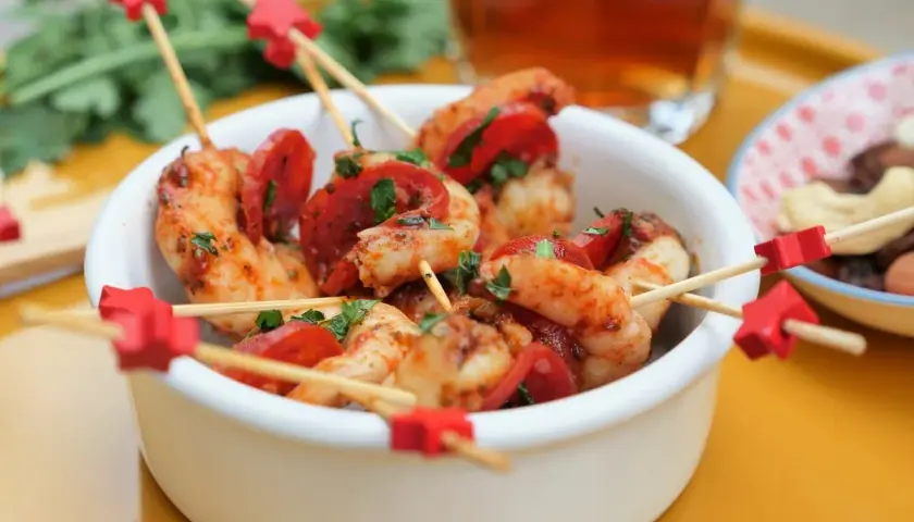 Brochettes crevette chorizo, garniture de persil frais, sur des bâtonnets décorés d'étoiles rouges. Un délice pour l'apéritif !