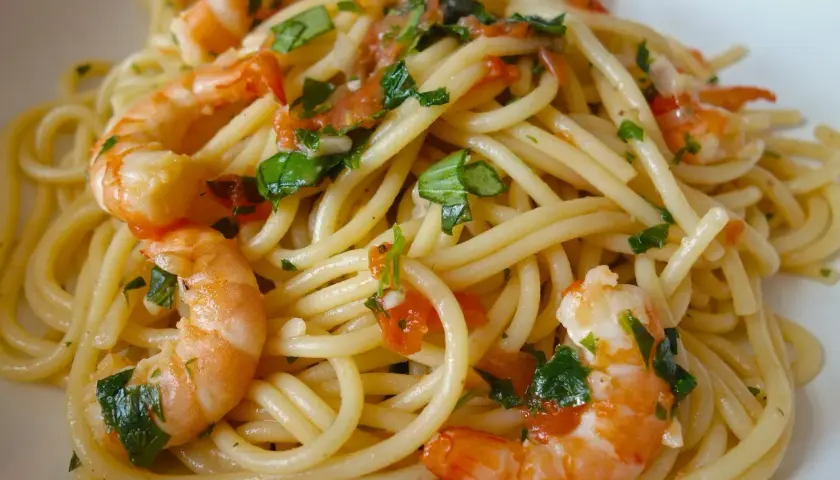 Spaghettis aux crevettes à l'ail et au persil, un plat savoureux et coloré, prêt à être dégusté.