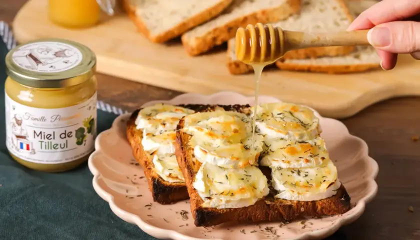 Une tartine alsacienne gourmande, garnie de fromage de chèvre fondant et arrosée de miel doré. Un délice à savourer !